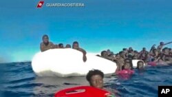 Gambar yang diambil dari video yang dikirimkan oleh Garda Pantai Italia, 6 Januari 2018 ini menunjukkan Migran yang terombang-ambing di Laut Mediterania, Libya ini mereka selamatkan saat mencoba menyeberang ke Italia. (Foto:Videograb/Italian Coast Guard via Ap).