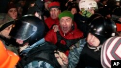 Pro-European Union activists block riot police near a Svyatoshin police station in Kyiv, Ukraine, Saturday, Jan. 11, 2014.