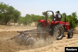 FILE - A farmer plows the field in Saulawa village, on the outskirts of Nigeria's north-central state of Kaduna, May 2013.