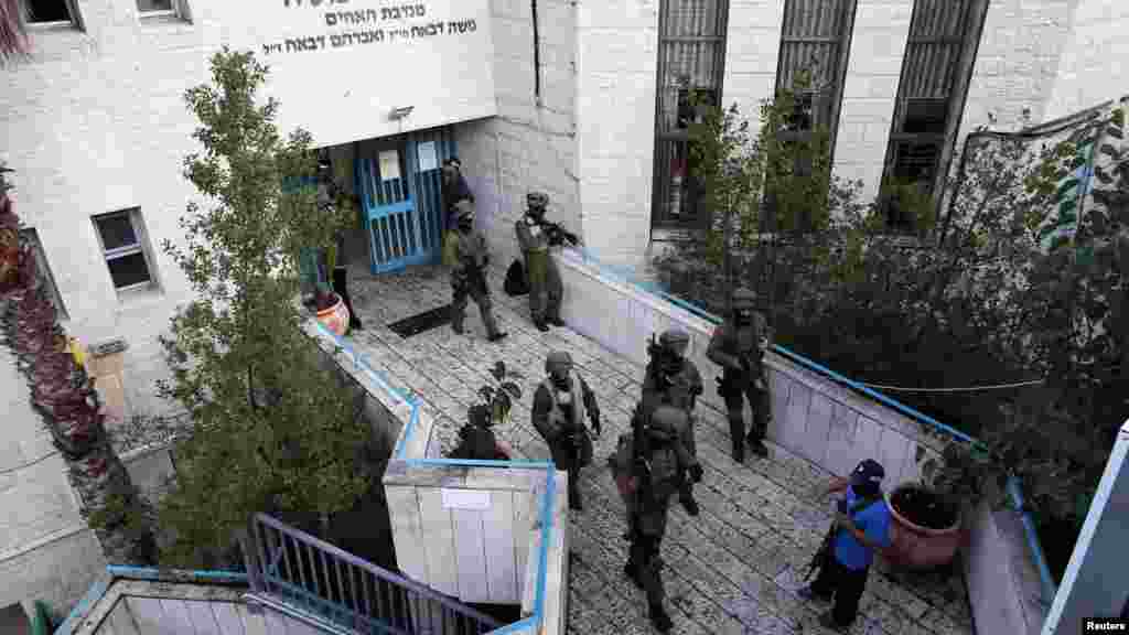 Israeli security personnel search a religious Jewish Yeshiva next to a synagogue, where a suspected Palestinian attack took place, in Jerusalem, November 18, 2014.
