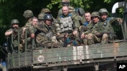 Binh sĩ Ukraine đang di chuyển trên một chiếc xe quân sự ở Mariinka, khu vực Donetsk, ngày 4/6/2015.