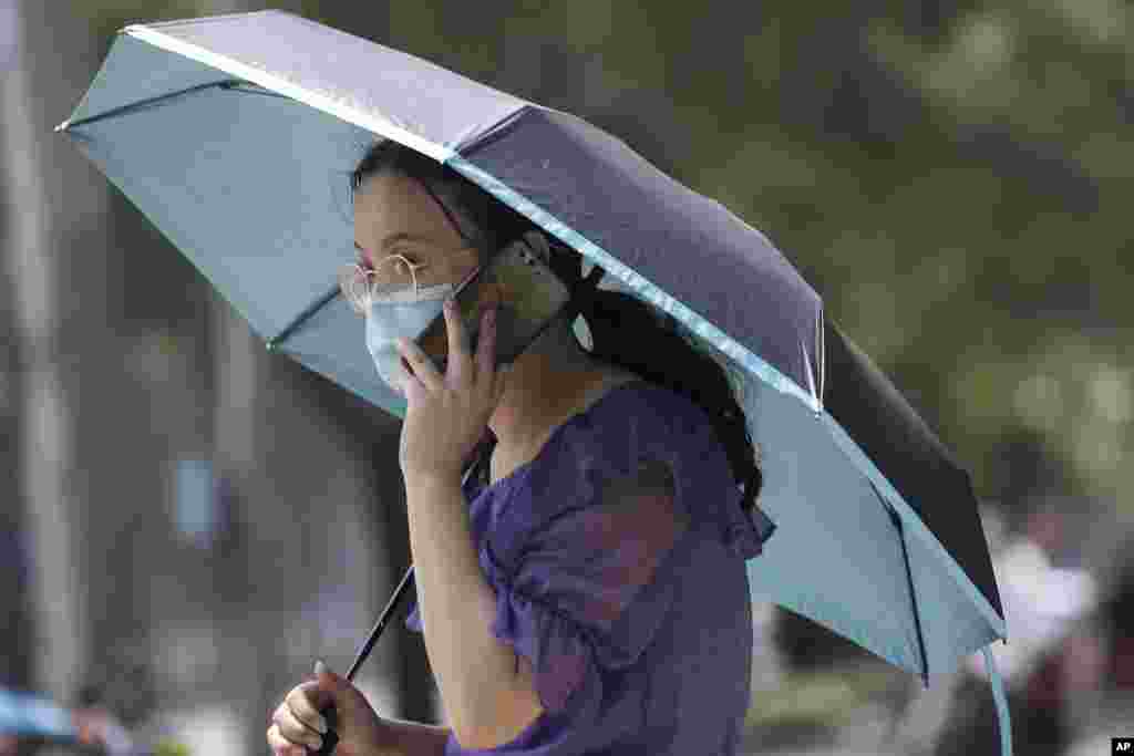 တရုတ်နိုင်ငံ Beijing မြို့က ဖုန်းပြောနေတဲ့ အမျိုးသမီးတဦး။ (ဇွန် ၁၉၊ ၂၀၂၀)