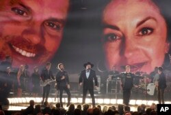 Joe Don Rooney,from left, Dierks Bentley, Eddie Montgomery, Gary LeVox, and Jay DeMarcus perform "My Town"during a tribute to Troy Gentry at the 51st annual CMA Awards at the Bridgestone Arena, Nov. 8, 2017, in Nashville, Tennessee.