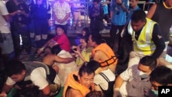 Du khách được cứu thoát trong một tai nạn lật tàu ngoài khơi đảo Phuket, Thái Lan, ngồi trên cầu tàu ngày 5/7/2018.