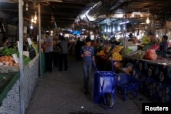 People shop for produce at a market in Kirkuk, Iraq, Oct. 19, 2017. On Friday, a bomb exploded in a crowded market, killing one woman and injuring 14 others, including women and children.