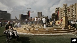 In this Sunday, Nov. 17, 2013 photo, Egyptian municipality laborers work on a memorial base two days before the commemoration of deadly clashes with security forces in 2011, in Tahrir Square, Cairo.