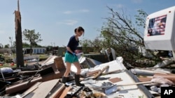 오클라호마와 텍사스 주에 홍수가 발생한 가운데 사진은 지난 7일 토네이도가 휩쓸고 지나간 오클라호마시티의 한 피해 현장을 한 여성이 살펴보고 있다. 