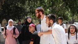 Sejumlah perempuan Palestina berteriak ke arah jemaah Yahudi setelah sempat bentrok antara polisi Israel dan warga Palestina di Masjid Alaqsa mengenai kunjungan jemaah Yahudi di Kuil Suci, di Yerusalem, Minggu, 18 Juli 2021. (Foto: Ammar Awad/Reuters)