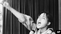 FILE -A young woman calls out to embolden her fellow Red Guards in Beijing's Tiananmen Square at the start of the 1966-76 Cultural Revolution, Aug. 10, 1966. May 16 is the 50-year anniversary of the start of the controversial campaign. 