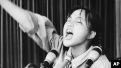 FILE -A young woman calls out to embolden her fellow Red Guards in Beijing's Tiananmen Square at the start of the 1966-76 Cultural Revolution, Aug. 10, 1966. May 16 is the 50-year anniversary of the start of the controversial campaign.