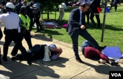 Demonstrators lie on the ground following a brawl with Turkish security personnel near the Turkish ambassador's residence in Washington, May 17, 2017. (screengrab from VOA Turkish video)