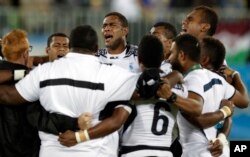 Fiji's players pray after winning the men's rugby sevens gold medal match against Britain at the Summer Olympics in Rio de Janeiro, Brazil, Aug. 11, 2016.