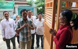 Newly elected commune chief from the opposition Cambodia National Rescue Party (CNRP) Sar Neang (2nd L) visits people in his commune, on the outskirts of Phnom Penh, Cambodia, June 8, 2017.