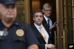 FILE - President Donald Trump's former attorney Michael Cohen, center, leaves Federal court in New York, Aug. 21, 2018.