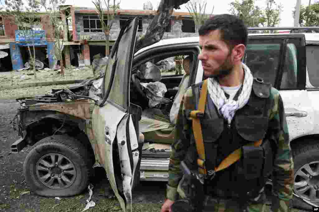 Security personnel stand near to site of suicide attack that struck the convoy of presidential candidate Abdullah Abdullah in Kabul, June 6, 2014.