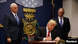 U.S. President Donald Trump signs a revised executive order for a U.S. travel ban on Monday, leaving Iraq off the list of targeted countries, at the Pentagon in Washington.