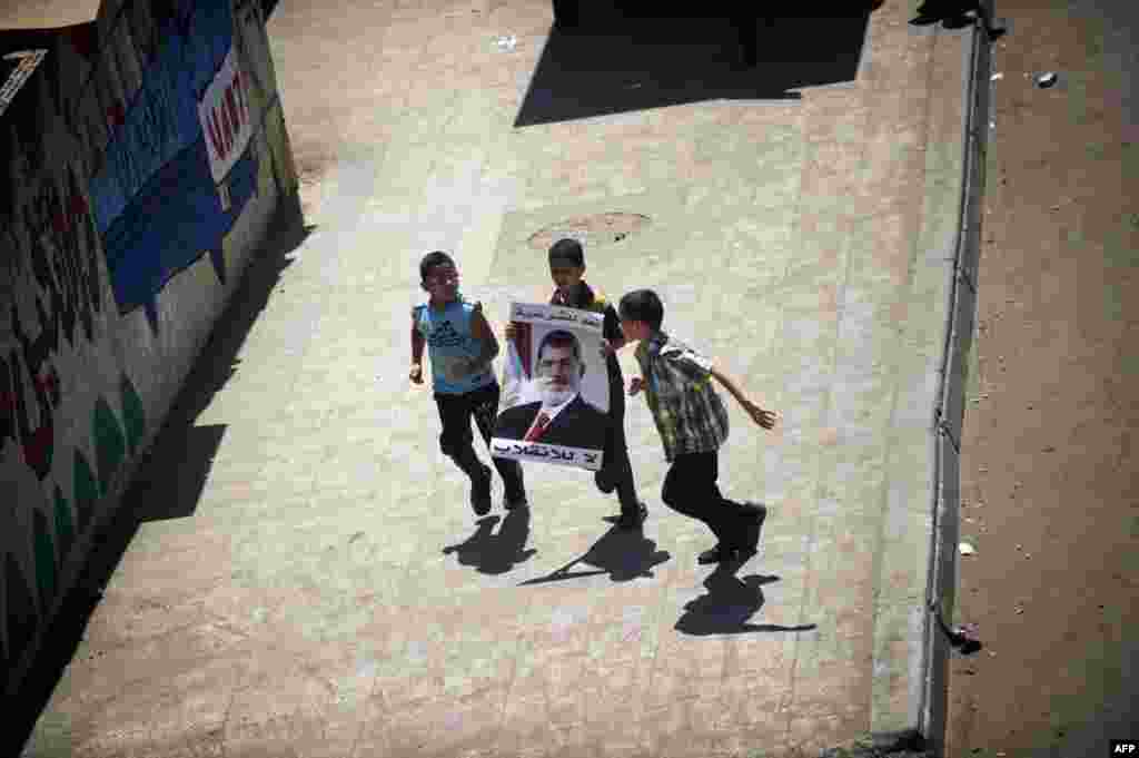 Egyptian children with portrait of Morsi run during a demonstration in support of the ousted president in Cairo, August 9, 2013.