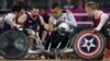  Japan's Shin Nakazato (C) holds onto the ball as Chuck Aoki of the US (L) closes in during the bronze medal Wheelchair Rugby match between USA and Japan, in London, September 9, 2012. 