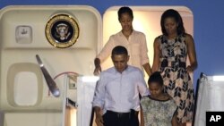 President Barack Obama arrives with first lady Michelle Obama, top, and daughters Malia, top left, and Sasha, bottom right, at Honolulu Joint Base Pearl Harbor-Hickam in Honolulu, for the start of their holiday vacation, Saturday, Dec. 22, 2012. 