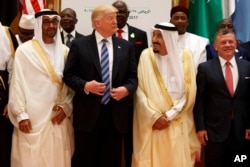 President Donald Trump talks with Saudi King Salman as they pose for photos with leaders at the Arab Islamic American Summit, at the King Abdulaziz Conference Center in Riyadh, Saudi Arabia, May 21, 2017. Jordan's King Abdallah II stands at right.