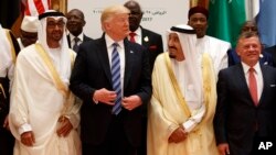 President Donald Trump talks with Saudi King Salman as they pose for photos with leaders at the Arab Islamic American Summit, at the King Abdulaziz Conference Center in Riyadh, Saudi Arabia, May 21, 2017. Jordan's King Abdallah II stands at right. 