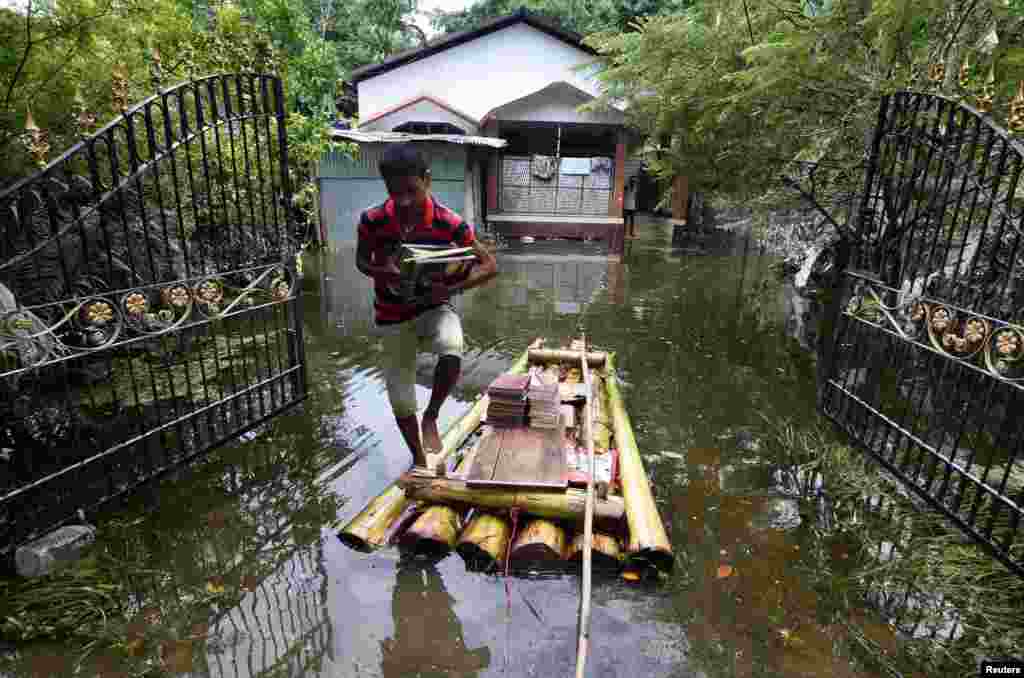 A boy uses a banana raft in the flooded area in Jakhalabandha in Nagaon district, in the northeastern state of Assam, India, Aug 21, 2017.