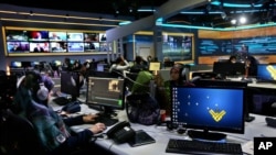 FILE - Employees work in the newsroom of Hezbollah’s Al-Manar TV station, in the southern suburb of Beirut, Lebanon, Dec. 10, 2015. 