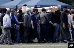 Mourners carry the body of a victim of the March 15 mosque shootings for burial at the Memorial Park Cemetery in Christchurch, New Zealand, March 20, 2019.
