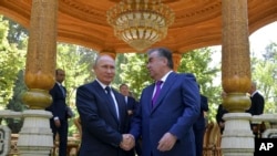 블라디미르 푸틴(왼쪽) 러시아 대통령이 지난 2018년 타지키스탄 방문 당시 에모말리 라흐몬 타지키스탄 대통령과 악수하고 있다. (자료사진)
