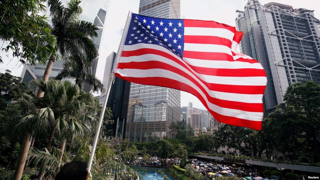Người biểu tình Hong Kong phất cờ Mỹ trong một cuộc tuần hành chống bạo lực của cảnh sát