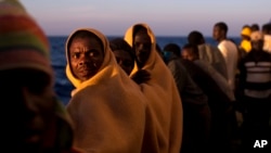 Men stand on the deck of the rescue vessel Golfo Azzurro after being rescued by Spanish NGO Proactiva Open Arms workers on the Mediterranean Sea, June 16, 2017. 