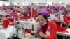 FILE: Garment workers sew clothes in a factory as they wait for visit by Prime Minister Hun Sen outside of Phnom Penh, Cambodia, Wednesday, Aug. 30, 2017. (AP Photo/Heng Sinith) 