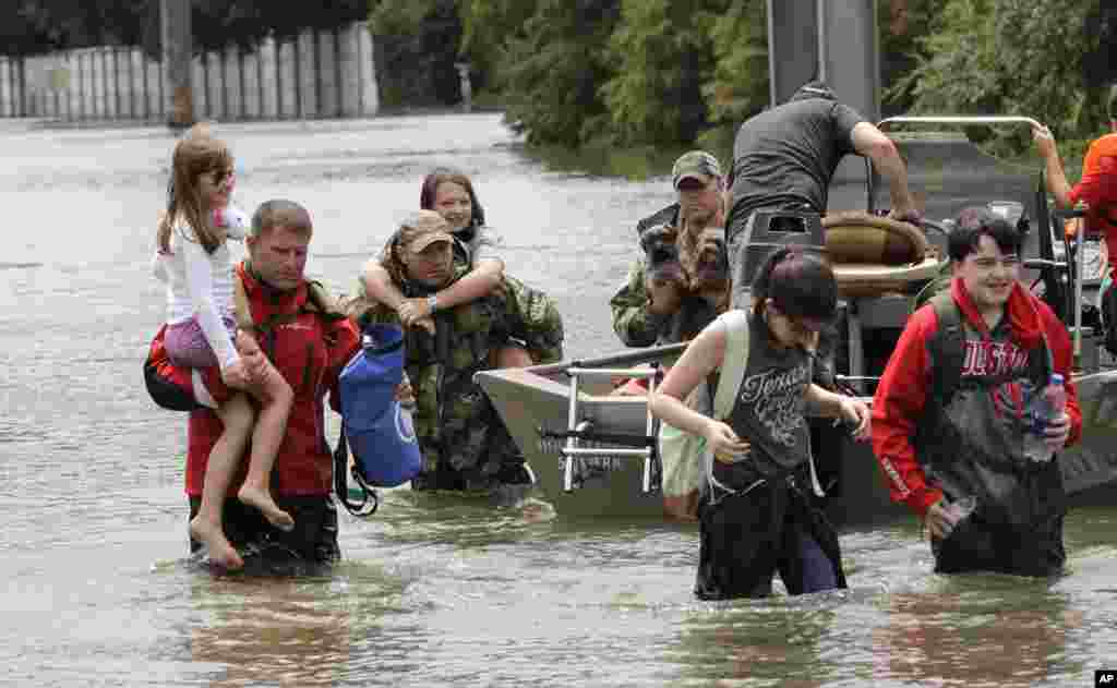 Residents are rescued from their homes surrounded by floodwaters from Tropical Storm Harvey on Sunday, Aug. 27, 2017, in Houston, Texas. (AP Photo/David J. Phillip)