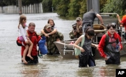 Residents are rescued from their homes surrounded by floodwaters from Tropical Storm Harvey on Sunday, Aug. 27, 2017, in Houston, Texas. (AP Photo/David J. Phillip)