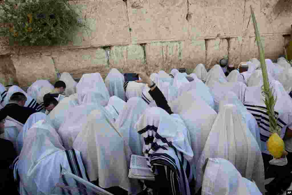 Covered in prayer shawls, ultra-Orthodox Jewish men pray during the holiday of Sukkot, at the Western Wall, the holiest site where Jews can pray in Jerusalem's Old City.