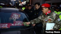 박근혜 전 대통령 구속영장 실질심사를 하루 앞둔 29일 서울 삼성동 자택 앞에서 구속을 요구하는 피켓 시위 차량에 지지자가 항의하고 있다. 