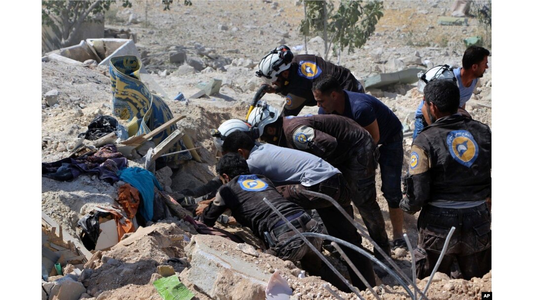 This photo provided by the Syrian Civil Defense White Helmets, which has been authenticated based on its contents and other AP reporting, shows Civil Defense workers searching through the rubble after airstrikes hit in Khan Sheikhoun.