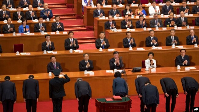 新任命的中国官员在全国人大会议宣誓就职后向中国国家主席习近平和其他主要领导人鞠躬。(2018年3月19日)