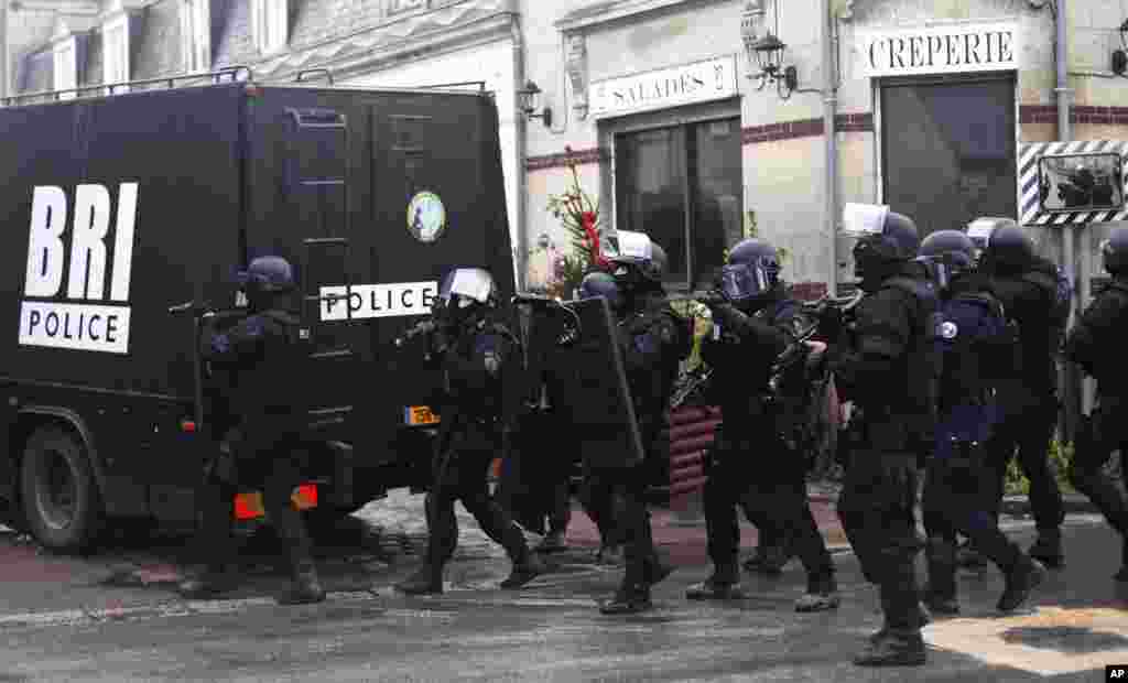 French riot officers patrol in Longpont, north of Paris. Police hunted down the two heavily armed brothers suspected in the massacre to make sure they don&#39;t strike again.