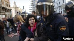 Polisi Spanyol mendorong para demonstran dalam aksi mogok di Madrid, Rabu (14/11).