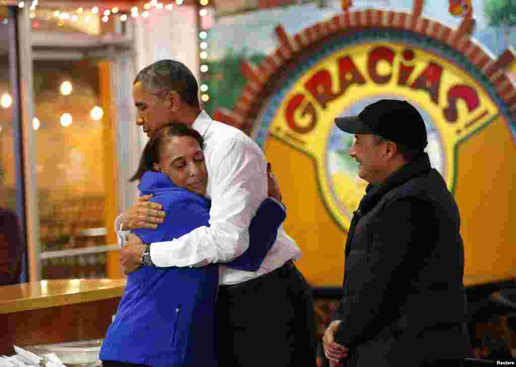 Devant un restaurant mexicain, le président Barack Obama reçoit un accueil chaleureux des propriétaires de La Hacienda, Lila Yepz à gauche et Carlos Yepez, avant que le président puisse commander son repas. Il est venu afin de parler des problèmes d&rsquo;immigration. Nashville, Tennessee, 8 décembre 2014. &nbsp;