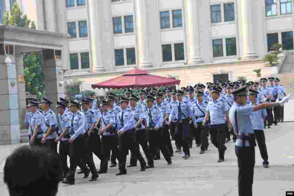 Chinese police officers march out of the Jinan Intermediate People's Court in Jinan in eastern China's Shandong province, August 21, 2013. (Wang Fei for VOA)