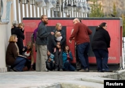 FILE - Foreigners evecauated by police from the site of an attack in Kabul are seen March 28, 2014. A group of Afghan Taliban insurgents forced their way into a guesthouse used by foreigners in an upscale residential part of the capital Kabul, police said.