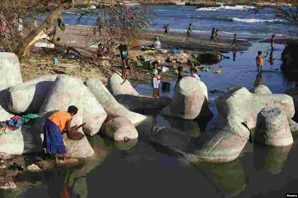 People wash their clothes on the beach at Lenakel town in Tanna, days after Cyclone Pam hit the South Pacific island nation. International aid agencies began emergency flights to some of the remote outer islands of Vanuatu, which they fear have been devastated by the monster cyclone.