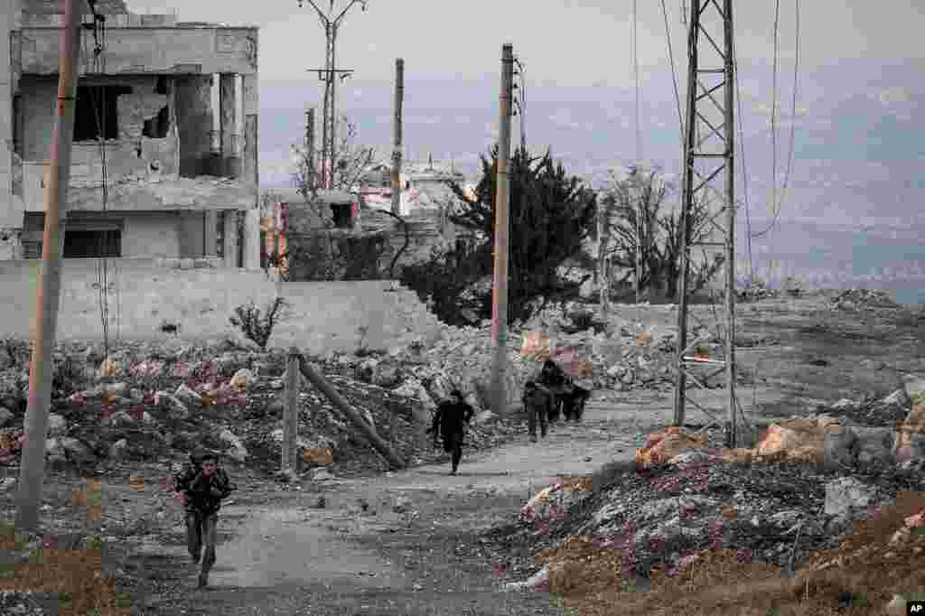 Syrian opposition fighters run for cover from sniper fire during skirmishes with government forces in Telata village in Idlib province, Sept. 29, 2013.