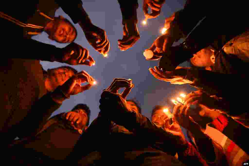 Nepali people take part in a candlelight vigil in honor of the plane crash victims in Kathmandu, a day after the deadly crash of a U.S.-Bangla Airlines plane at the international airport.
