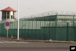 In this Dec. 3, 2018, photo, a guard tower and barbed wire fences are seen around a facility in the Kunshan Industrial Park in Artux in western China's Xinjiang region. This is one of a growing number of internment camps in the Xinjiang region.