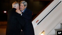 U.S. Secretary of State John Kerry, right, is greeted by U.S. Ambassador Louis Susman upon his arrival in Britain marking the start of his first official trip overseas, at Stansted Airport east of London, Feb. 24, 2013.