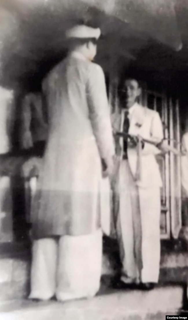 Trưởng đoàn đại biểu Chính phủ lâm thời Việt Nam Dân chủ Cộng hòa Trần Huy Liệu (phải) nhận kiếm từ vua Bảo Đại tại lễ thoái vị, chiều 30.8.1945. Nguồn: Lưu trữ Cộng hòa Pháp.