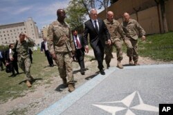 U.S. Defense Secretary James Mattis, third right, walks with U.S. Army Command Sergeant Major David Clark, left, and General Christopher Haas, second right, as he arrives at the Resolute Support headquarters in Kabul, Afghanistan, April 24, 2017.